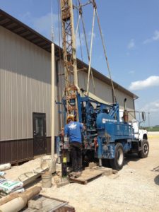 Illinois licensed water well drillers inspecting a worksite with equipment
