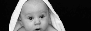 A baby with a towel draped over the top of it's head