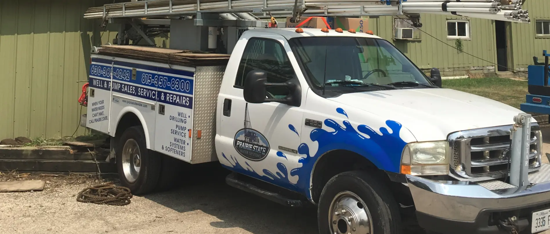 A Prairie State Water Systems service truck parked in front a building for on-site water pump maintenance